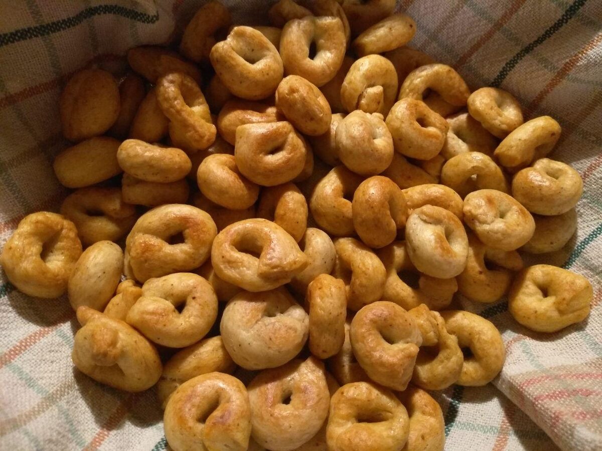 A pile of crisp taralli, savory Puglian rings, on a checked cloth