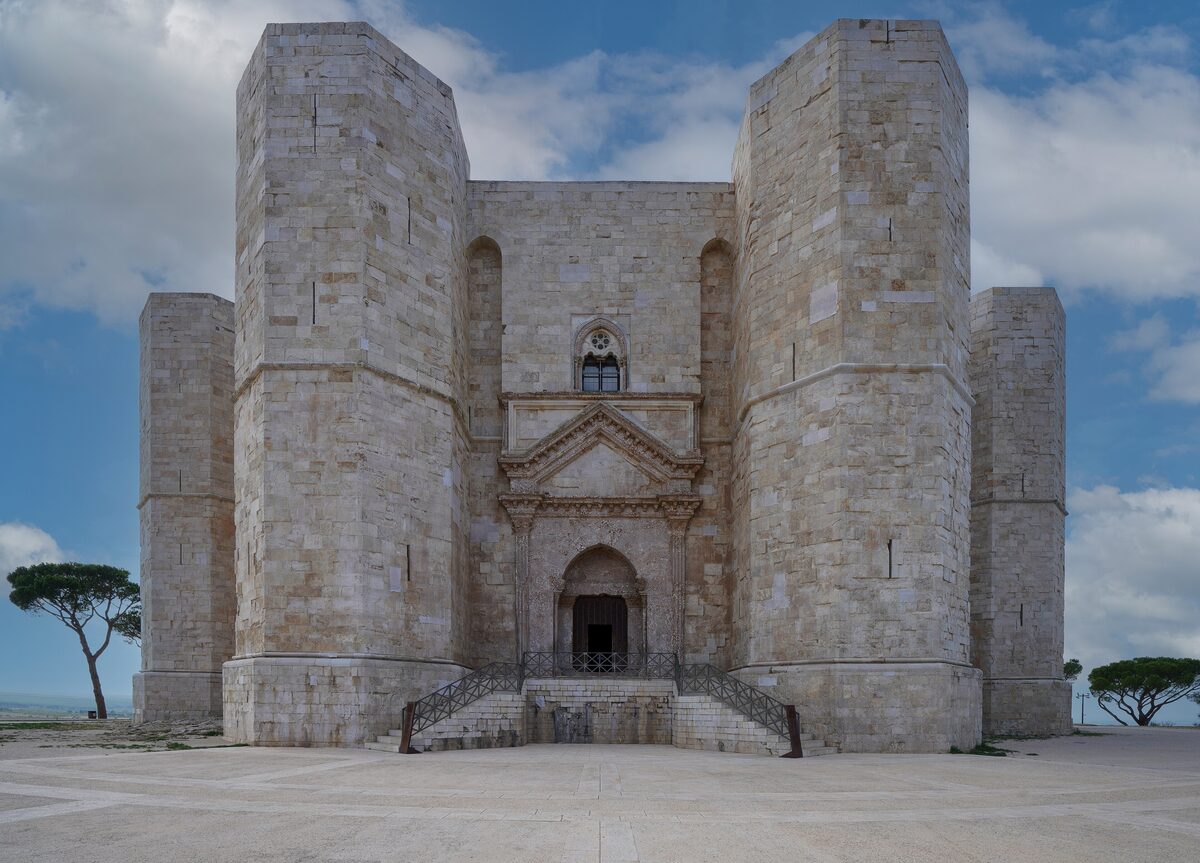 The octagonal Castel del Monte, with its stone towers and doorway seen from the front