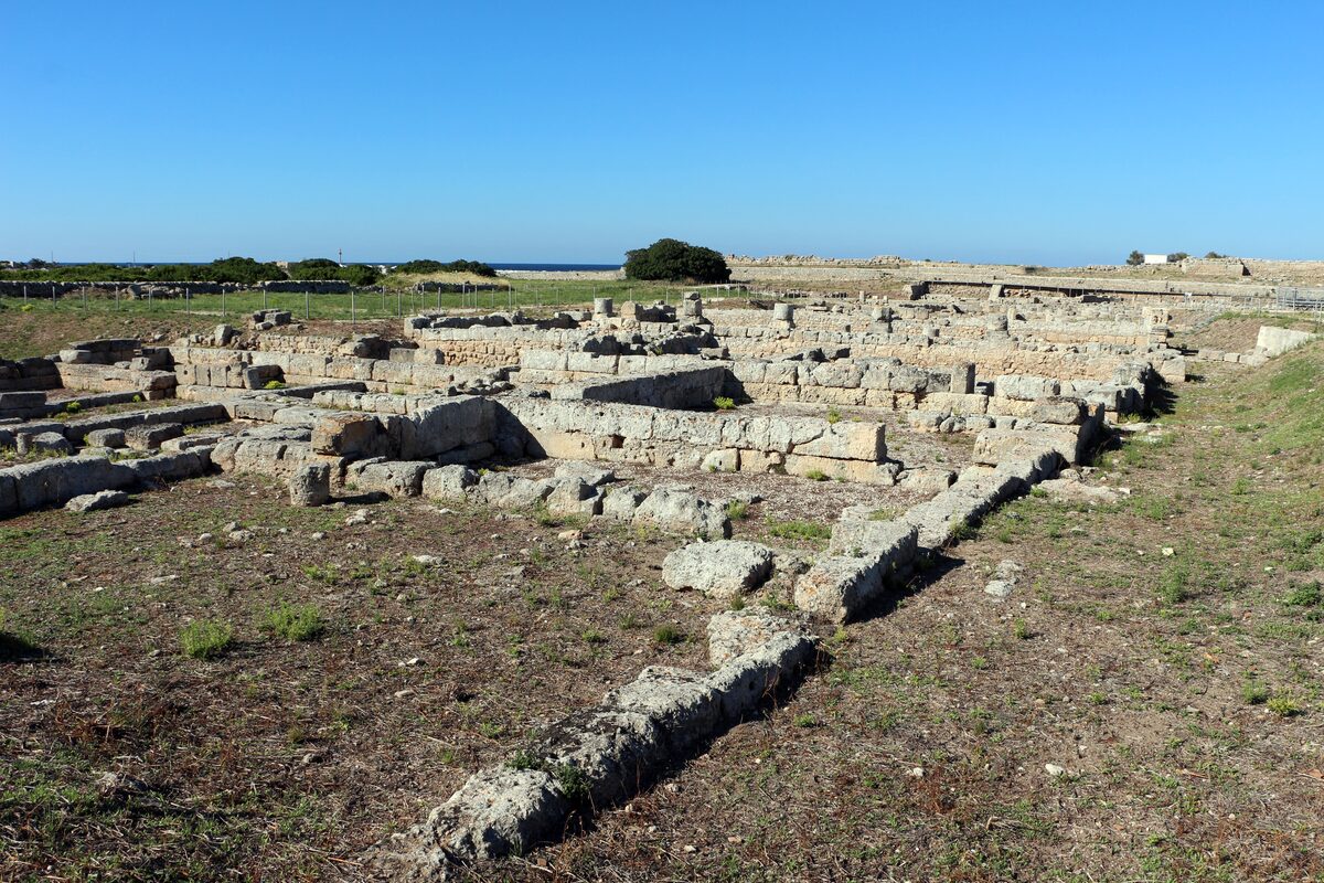 Excavated foundations of the ancient streets of Egnazia in the grass near the sea