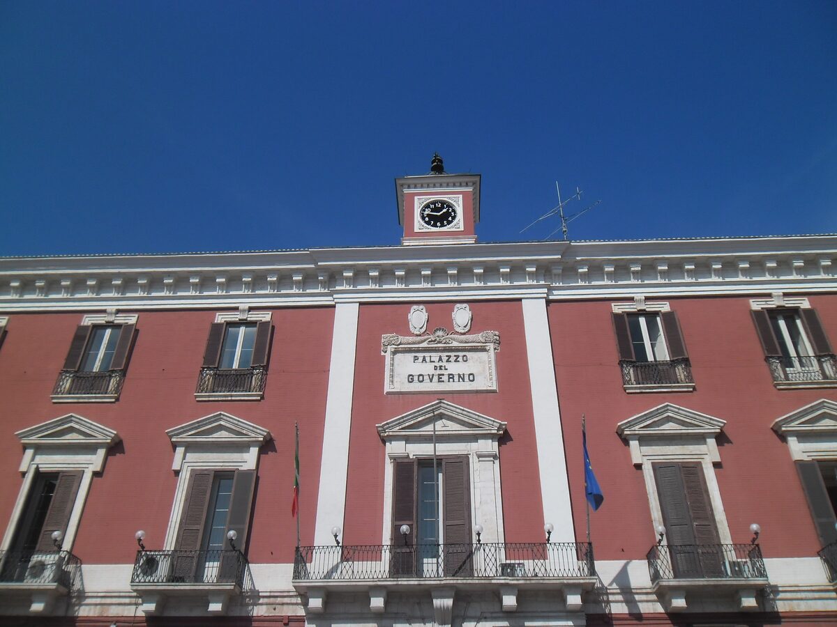 The red Palazzo del Governo in Bari, with its clock tower and balconied windows