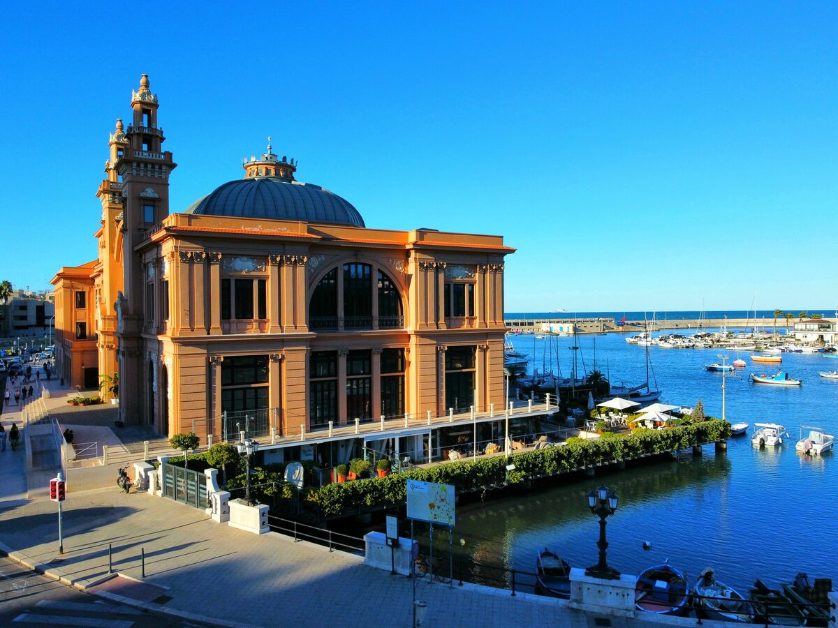 The Teatro Margherita beside the harbour, with fishing boats moored along the quay in front