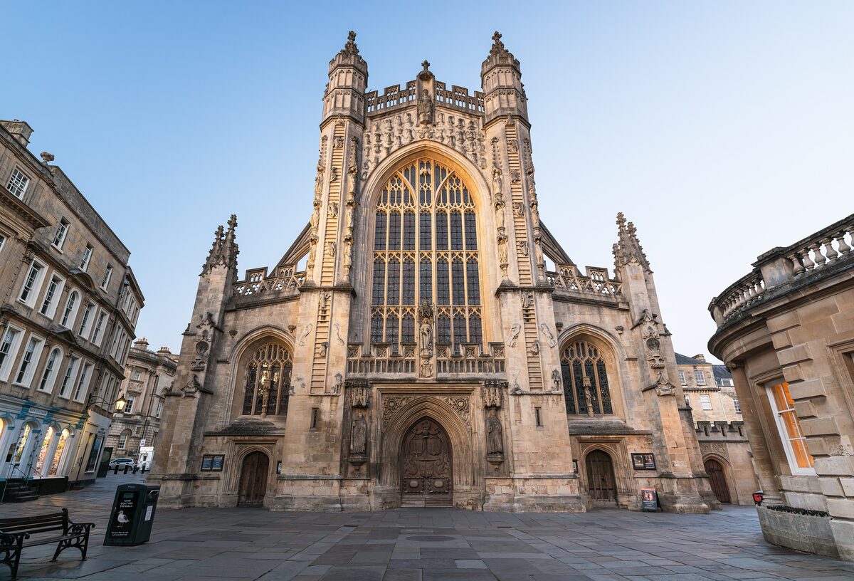 The west front of Bath Abbey with its tall Gothic window and carved ladders of angels on either side