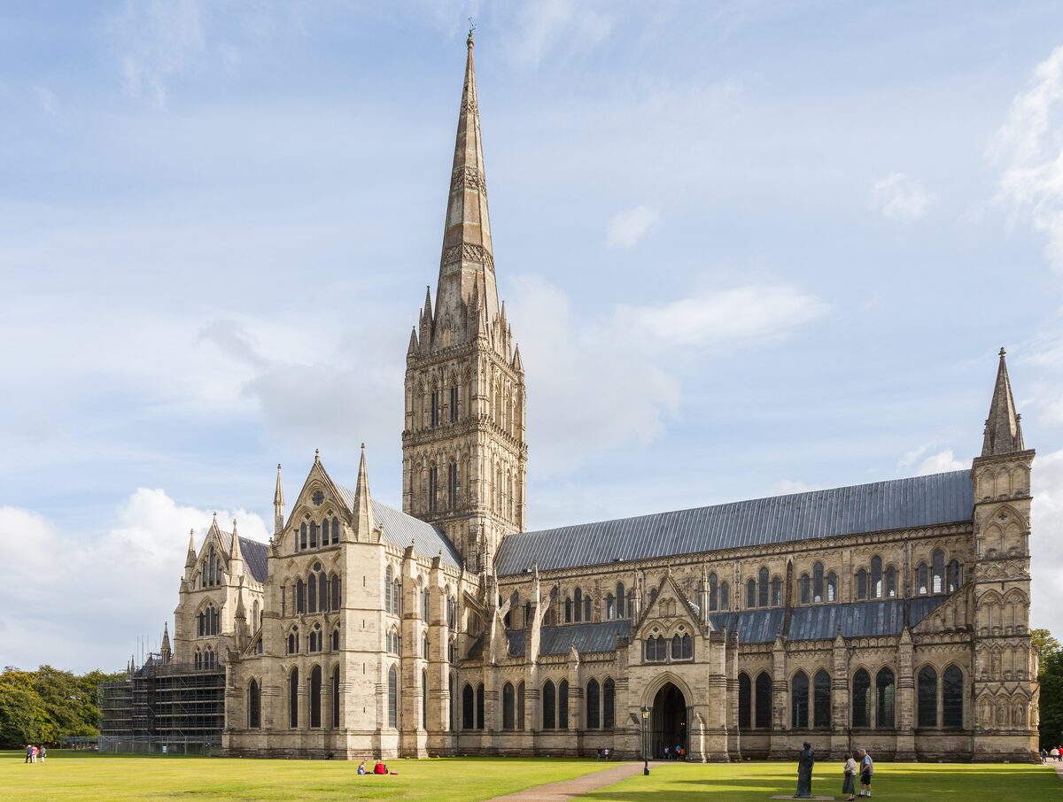 Salisbury Cathedral with its tall spire above a wide green lawn in the Cathedral Close