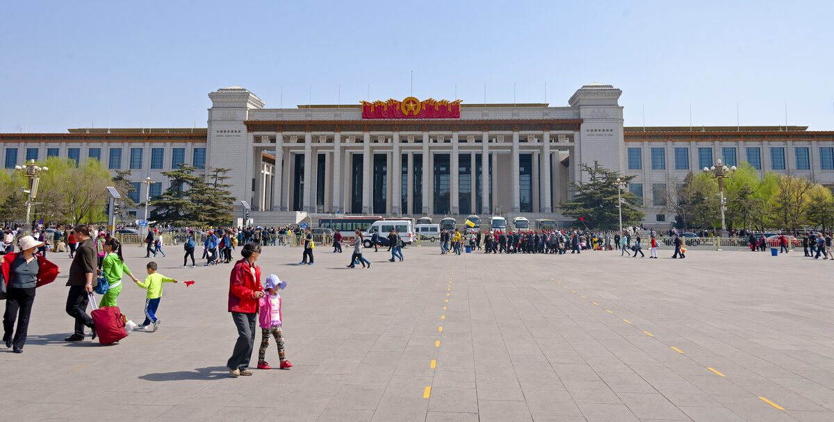 The long colonnaded facade of the National Museum of China on the east side of Tiananmen Square, with visitors on the square in front