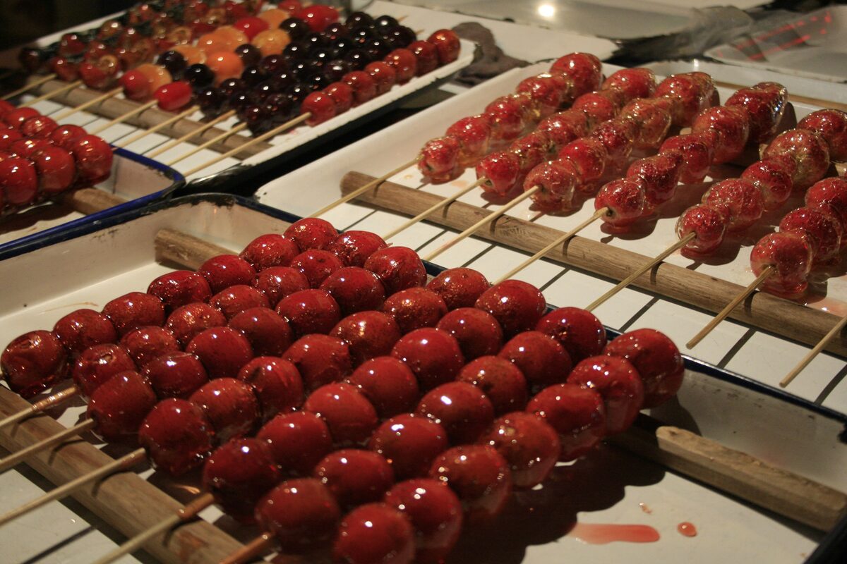 Trays of hawthorn fruits on bamboo skewers coated in glossy red sugar syrup