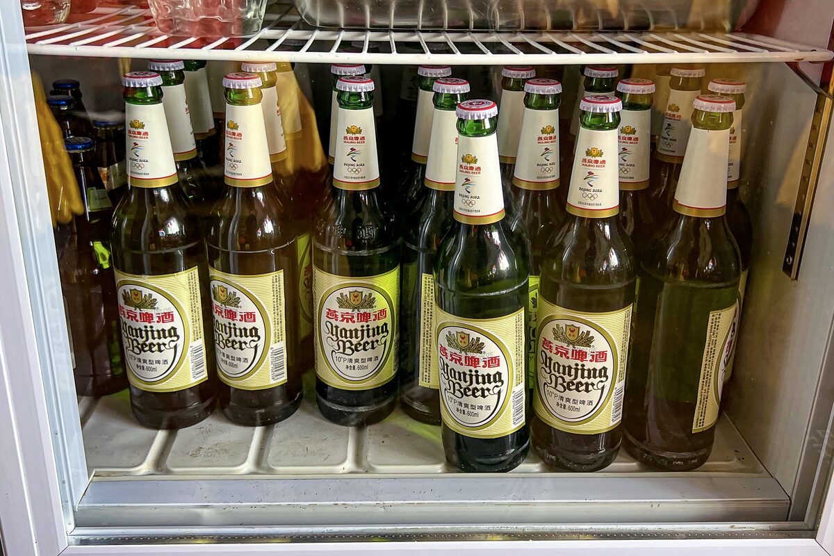 Chilled bottles of Yanjing beer with yellow labels lined up in a restaurant fridge