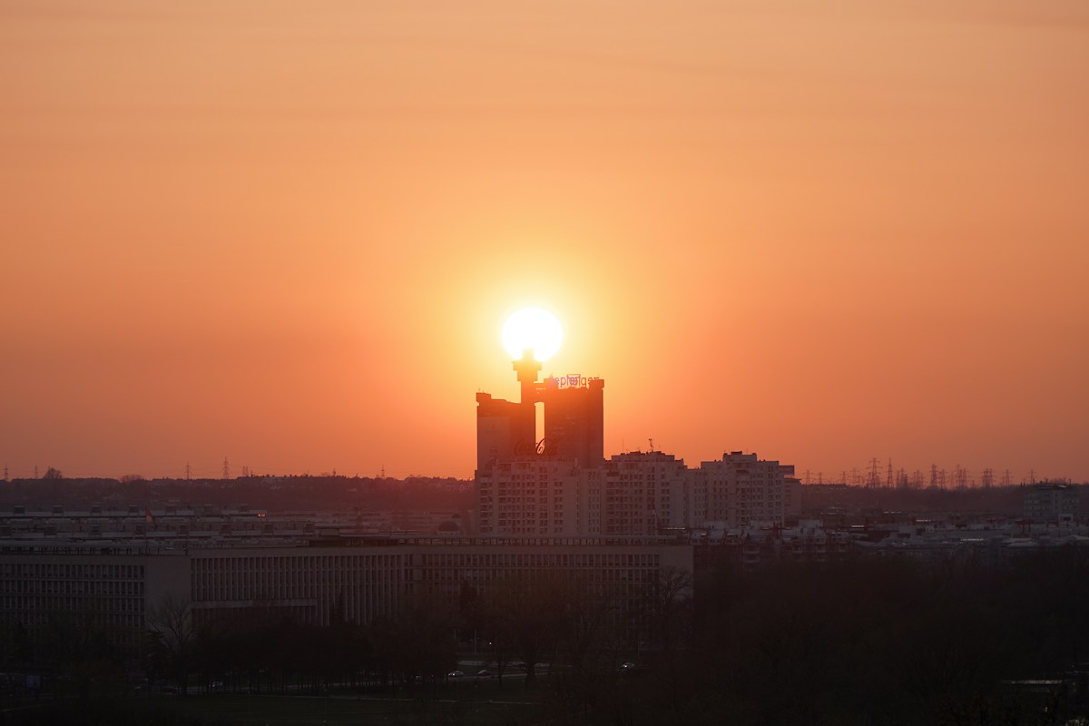 The Genex Tower in New Belgrade, two towers joined by a bridge, silhouetted against the setting sun