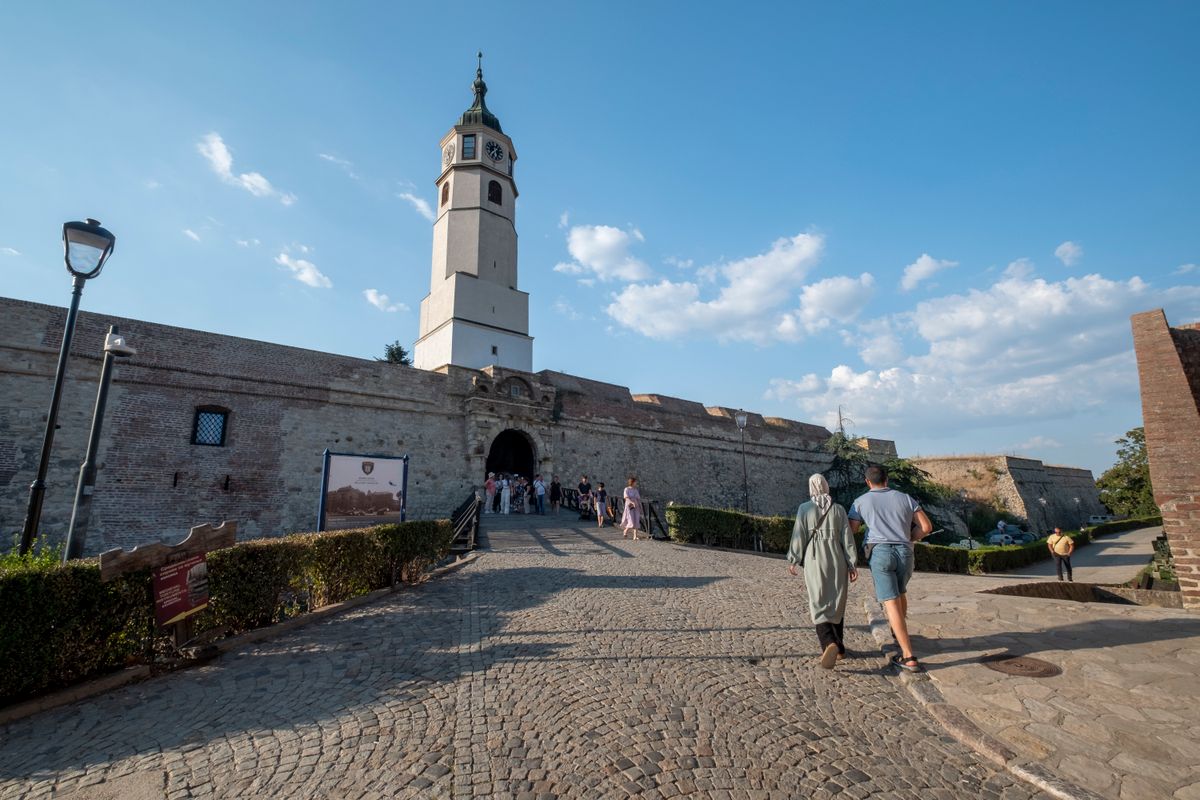 The clock tower and gate of Belgrade Fortress above a cobbled path at Kalemegdan