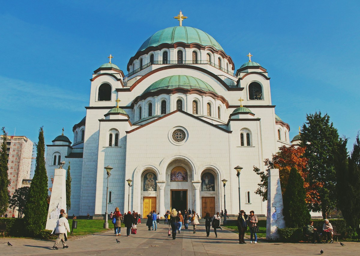 The white marble Church of Saint Sava in Belgrade with its green domes and gold crosses