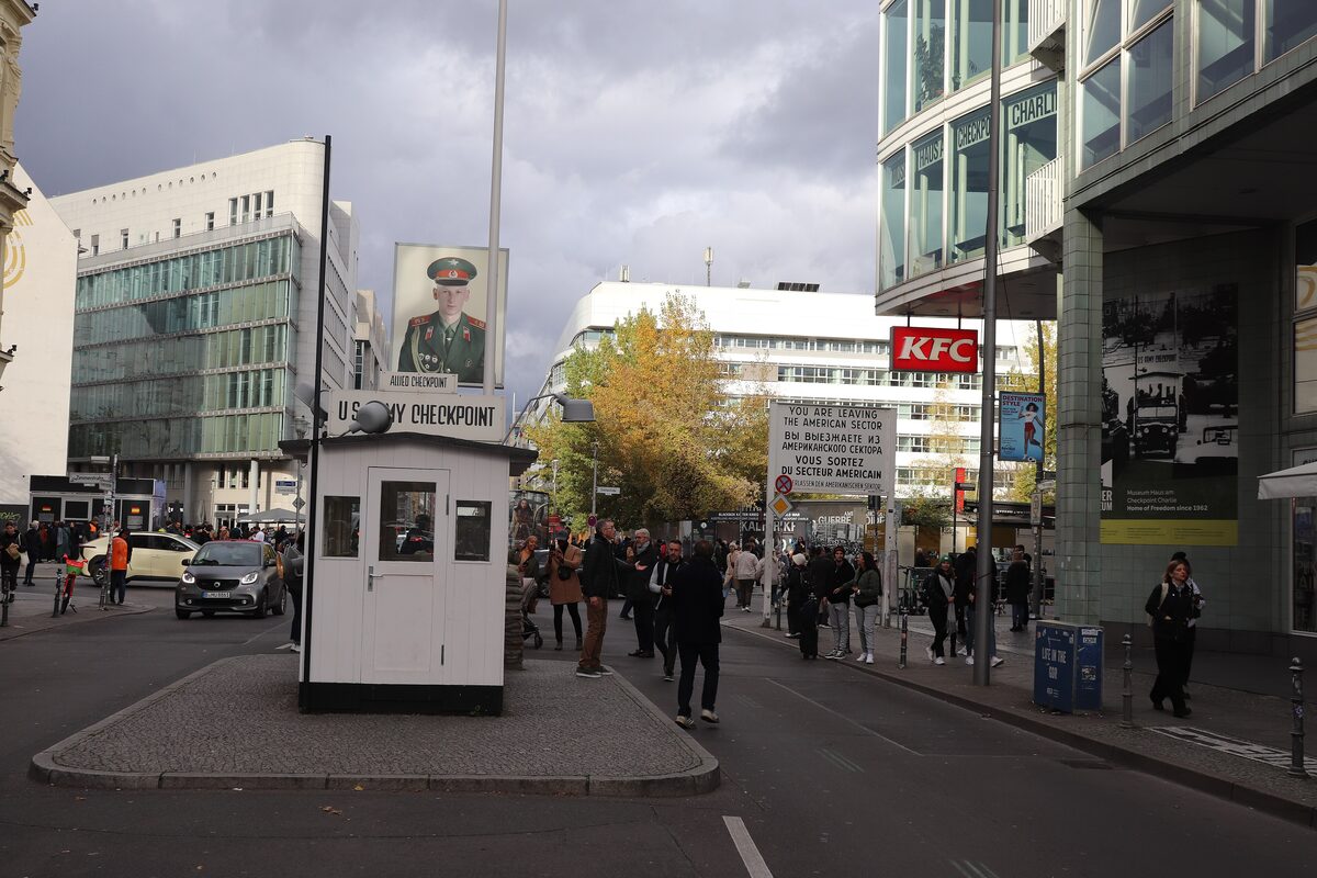 The replica guardhouse at Checkpoint Charlie with its sandbags, the portrait of a US soldier on a pole and crowds of visitors