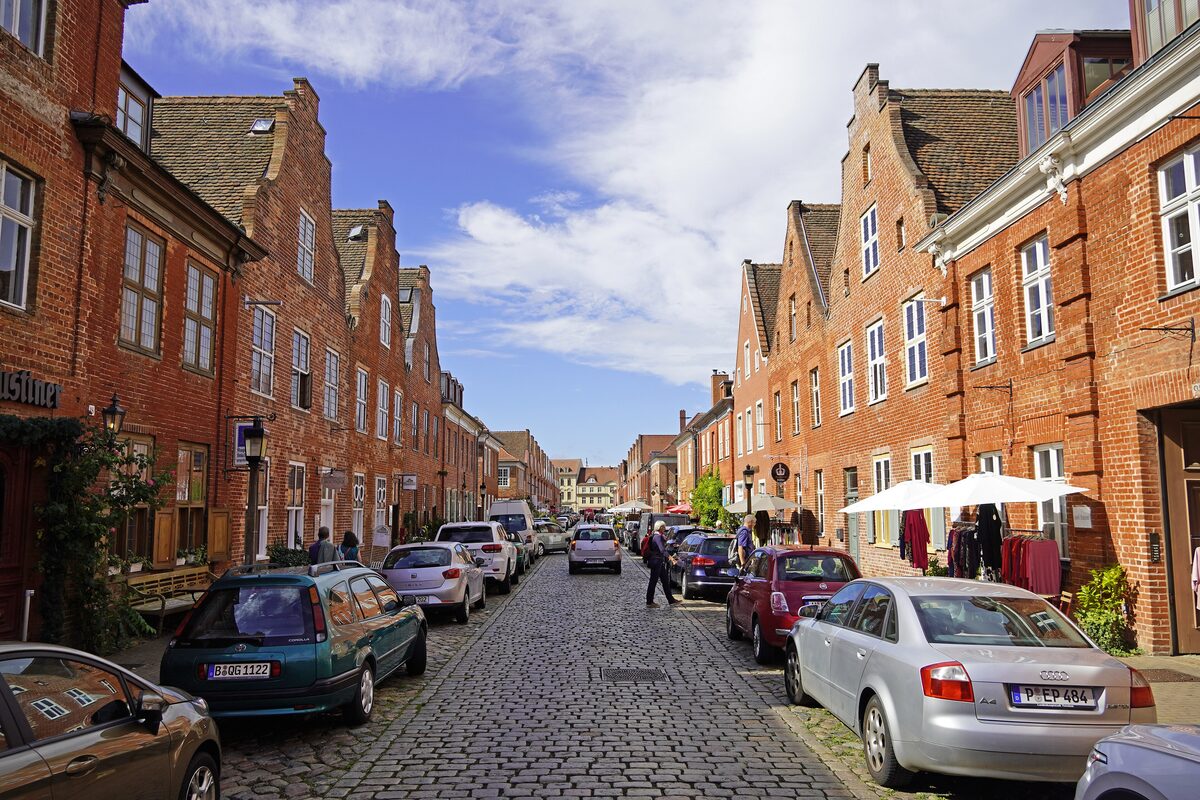 A cobbled street in Potsdam's Dutch Quarter, lined with red-brick houses with gabled roofs