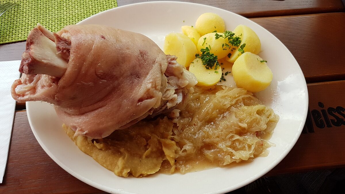 A plate of Eisbein, boiled pork knuckle, with sauerkraut and boiled potatoes