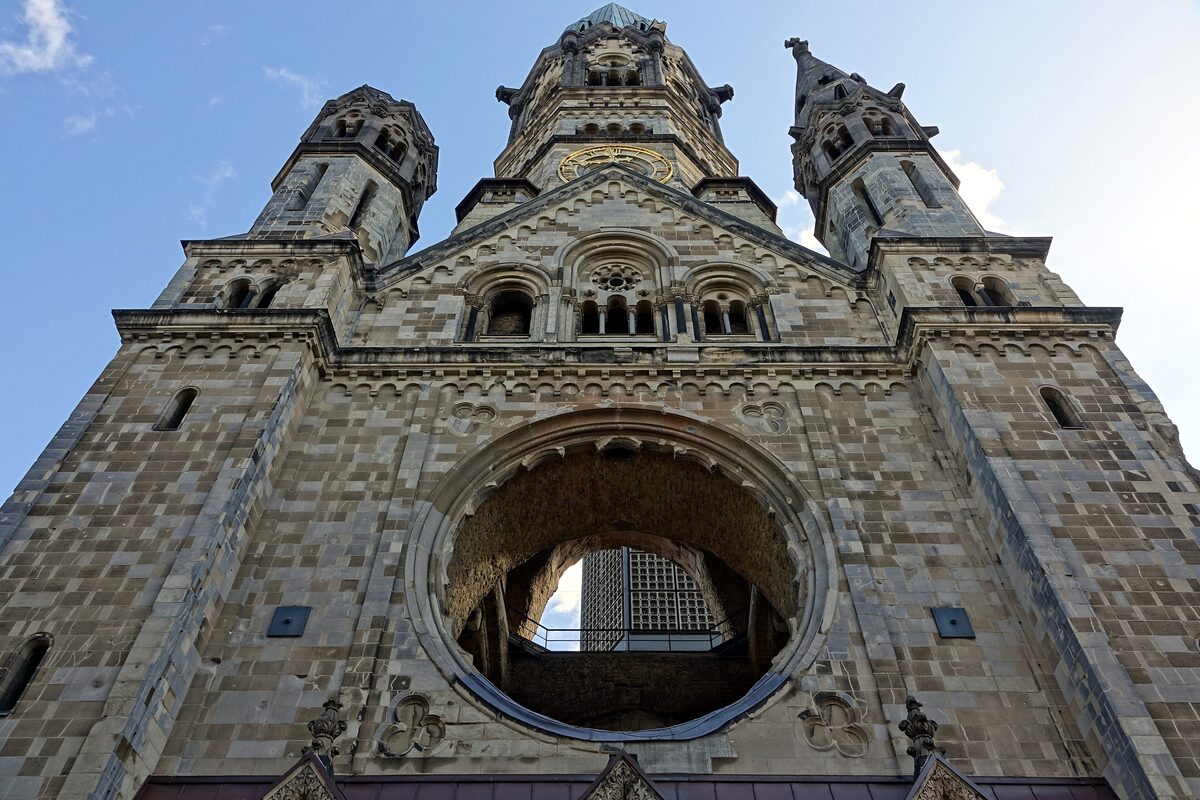 Looking up at the front of the Kaiser Wilhelm Memorial Church, its bombed towers and round window opening onto the sky