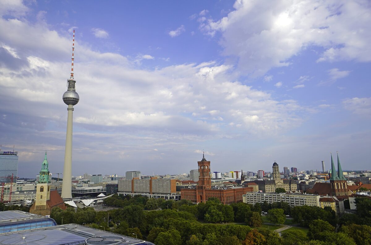 The Berlin TV Tower rising above the red-brick Rotes Rathaus and the green park around it