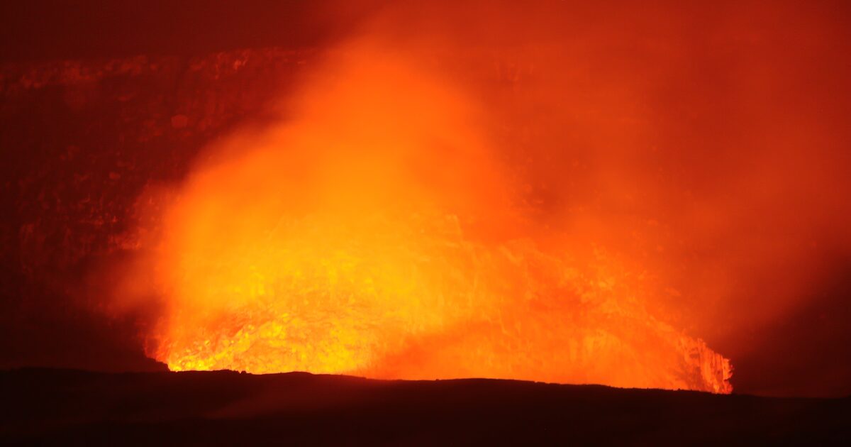 Orange lava glow lighting the Halemaʻumaʻu crater under a night sky