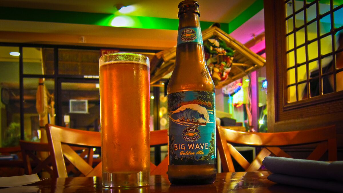Big Wave Golden Ale bottle beside a full glass of beer