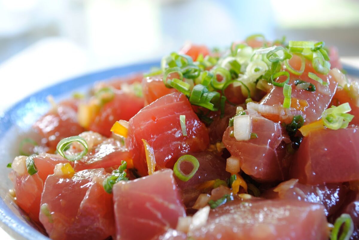 A bowl of cubed raw ahi tuna poke with green onion