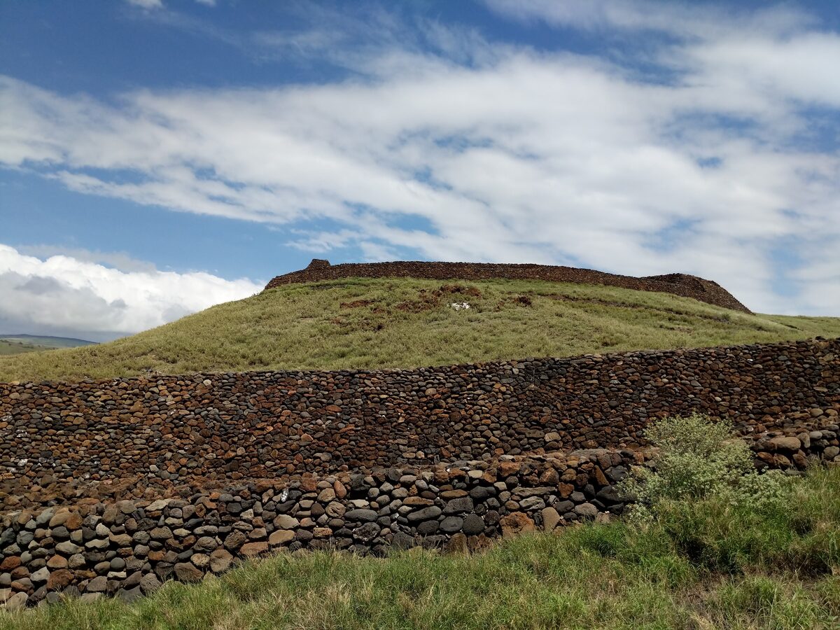Stone walls of Puʻukoholā Heiau on a green hillside
