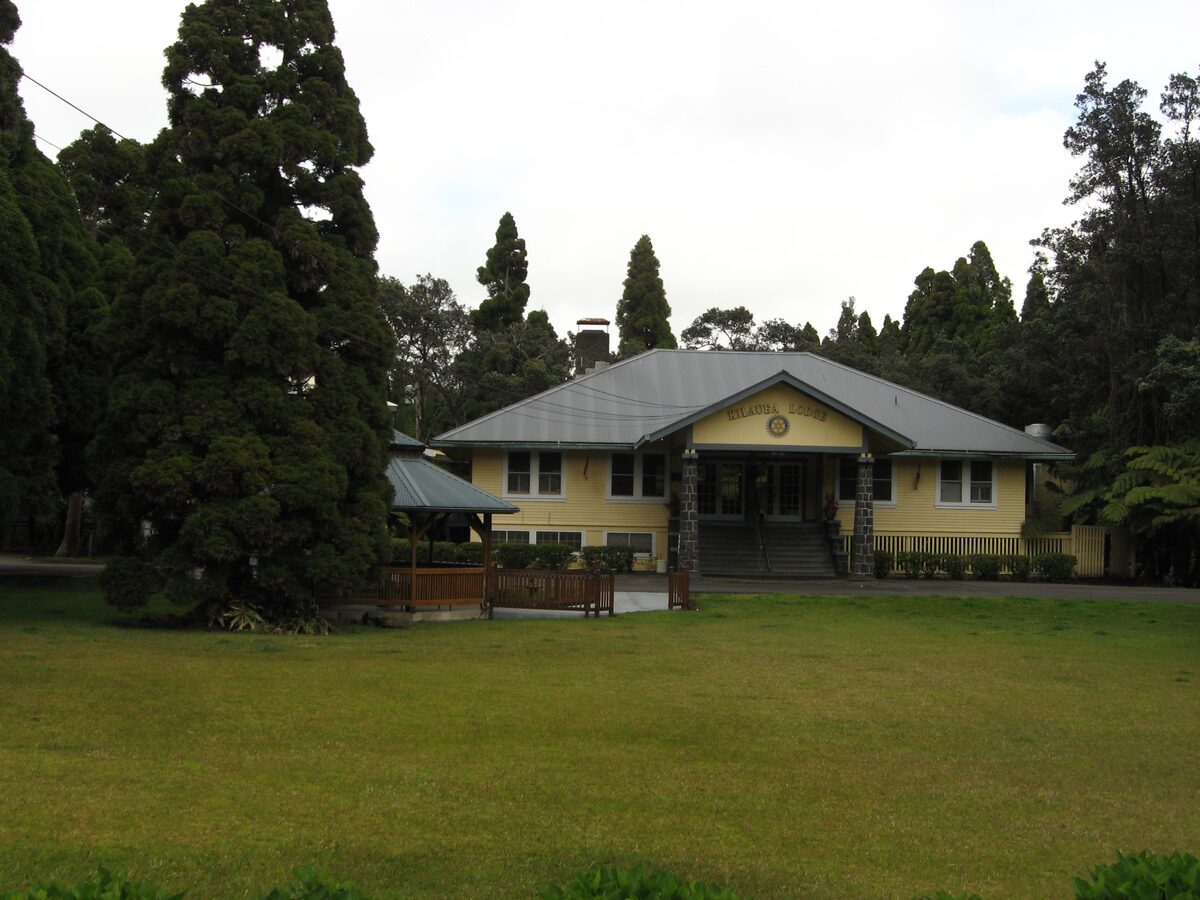 Wooden house on a lawn among tall conifers in Volcano