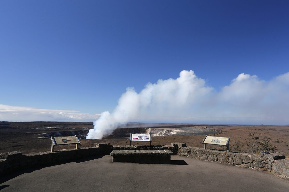 Steam rising from Halemaʻumaʻu seen from a stone-walled overlook