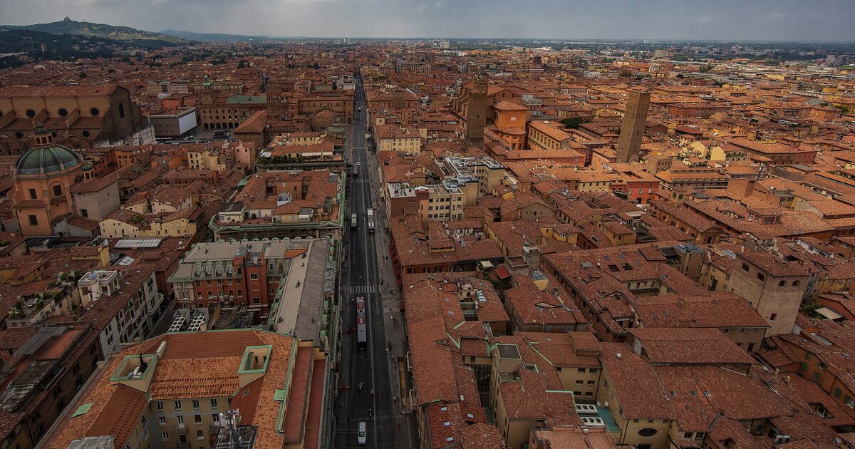Red rooftops of Bologna seen from the Torre degli Asinelli, with San Petronio on the left and the San Luca hill far behind