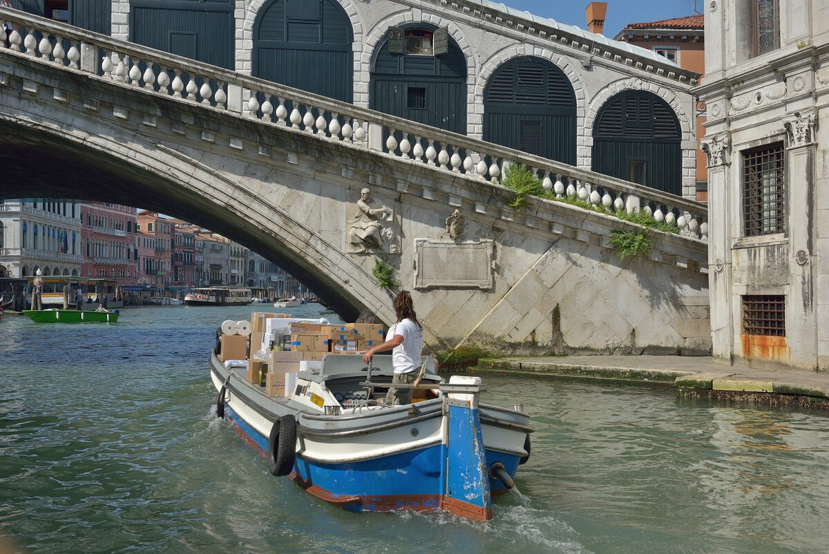 A motorboat passing under the Rialto Bridge on the Grand Canal in Venice