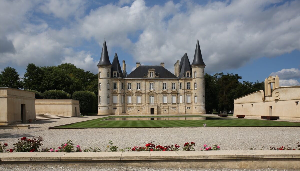 Château Pichon-Longueville in Pauillac, a turreted 19th-century château behind a long lawn and rose beds