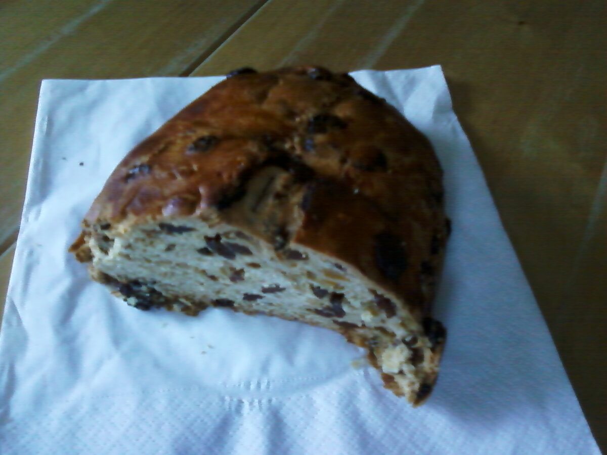 A bisciola, the dense fruit and nut bread of Valtellina, with a slice cut from the loaf on a paper napkin