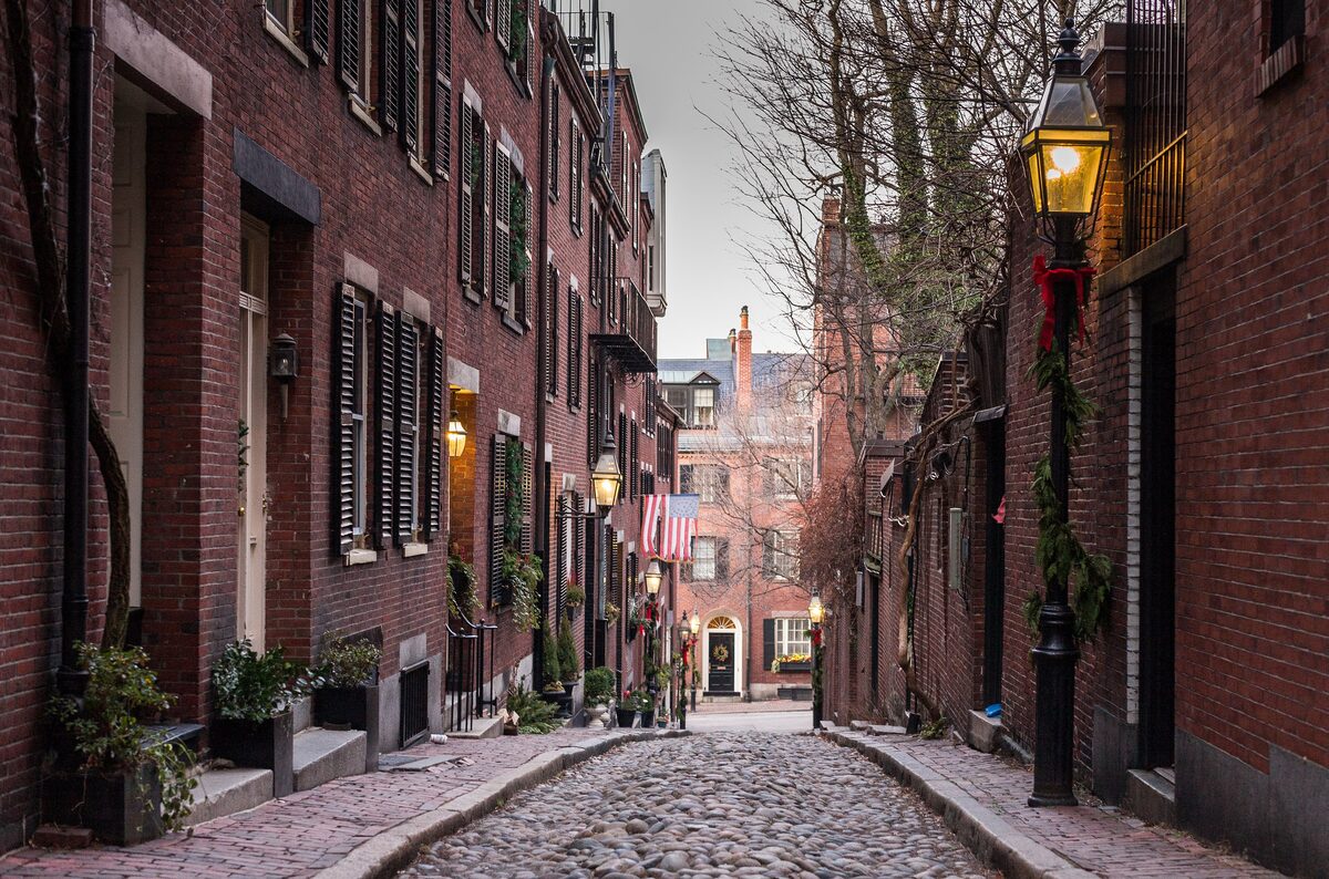 Gas lamps and brick rowhouses along cobbled Acorn Street on Beacon Hill