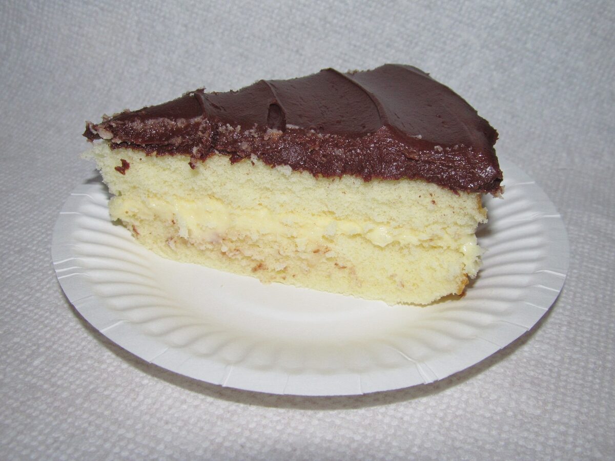 A slice of Boston cream pie with custard and chocolate glaze