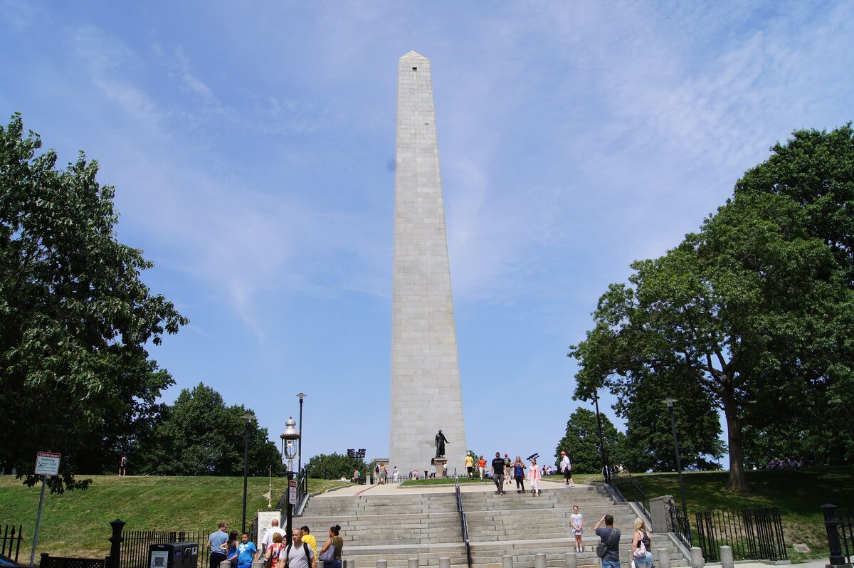 The granite Bunker Hill Monument obelisk above its steps and trees