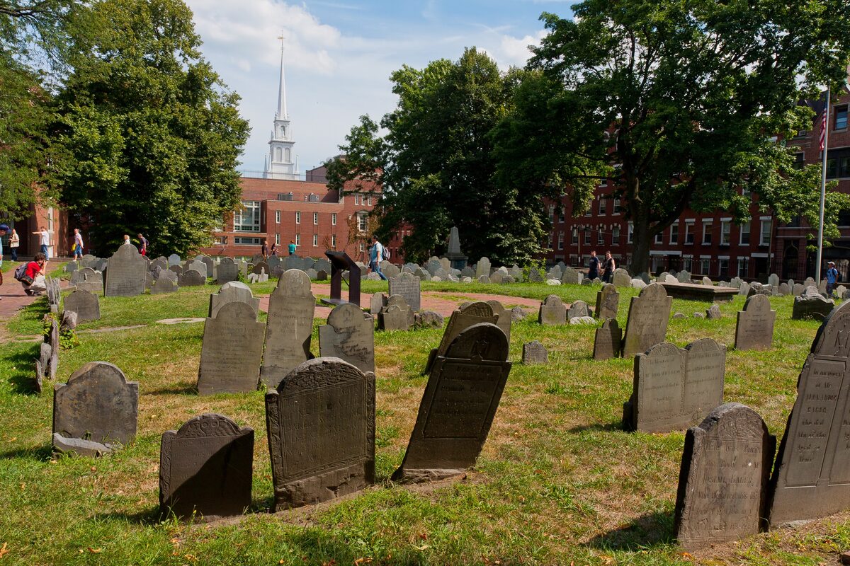 Slate headstones on the grass of Copp's Hill with Old North's steeple behind