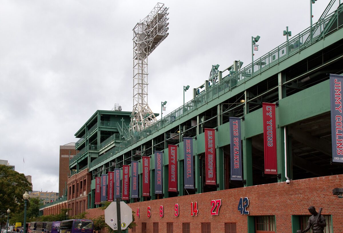The green outer wall of Fenway Park hung with retired-number banners
