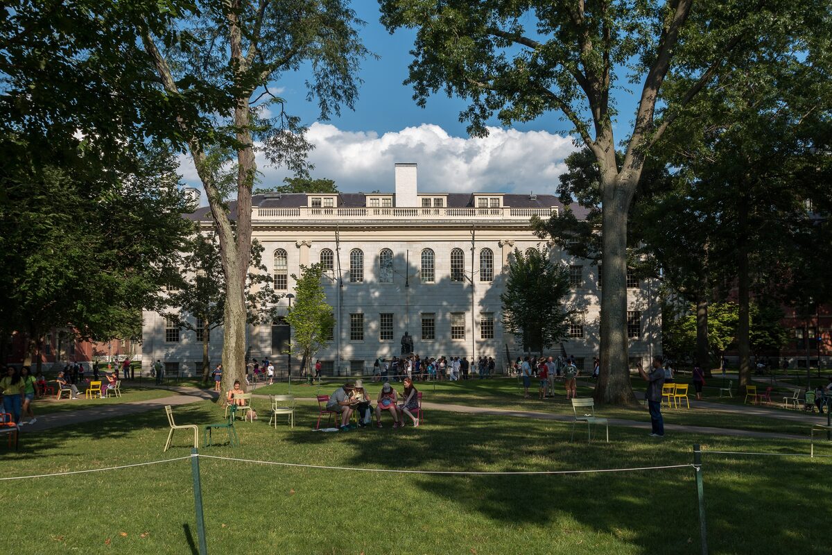 Students on the lawn of Harvard Yard in front of a Georgian hall