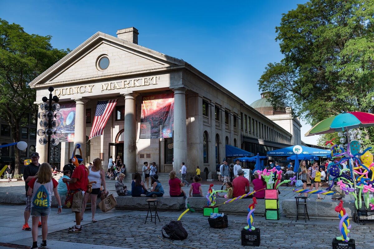 The columned granite front of Quincy Market with crowds and street performers