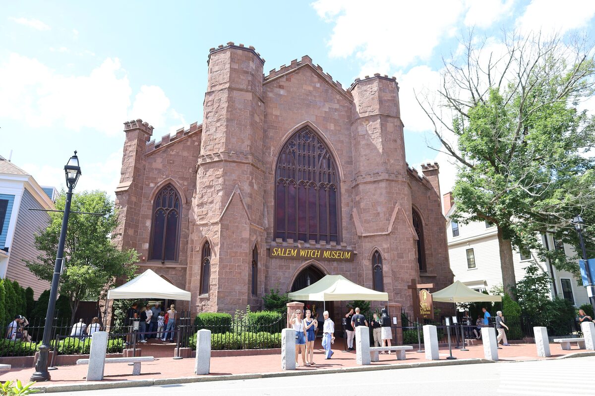 The turreted stone front of the Salem Witch Museum with visitors outside
