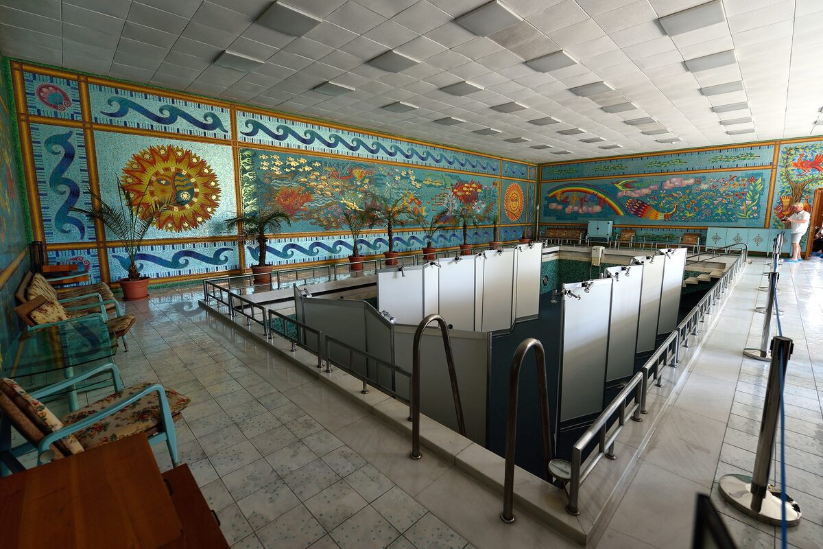 The indoor pool of the Ceaușescus' Spring Palace, its walls covered in turquoise mosaics of a sun, fish, waves and a rainbow