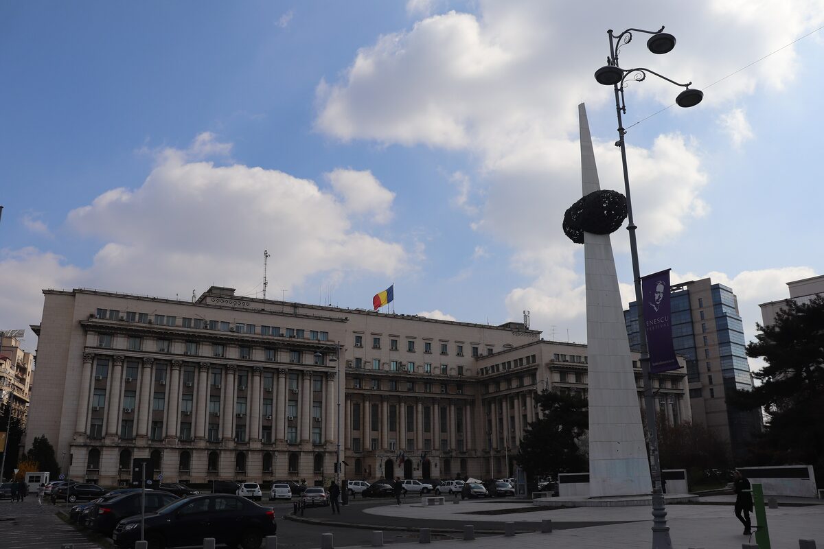 Revolution Square with the white marble Memorial of Rebirth and its dark crown, in front of the long columned former Central Committee building