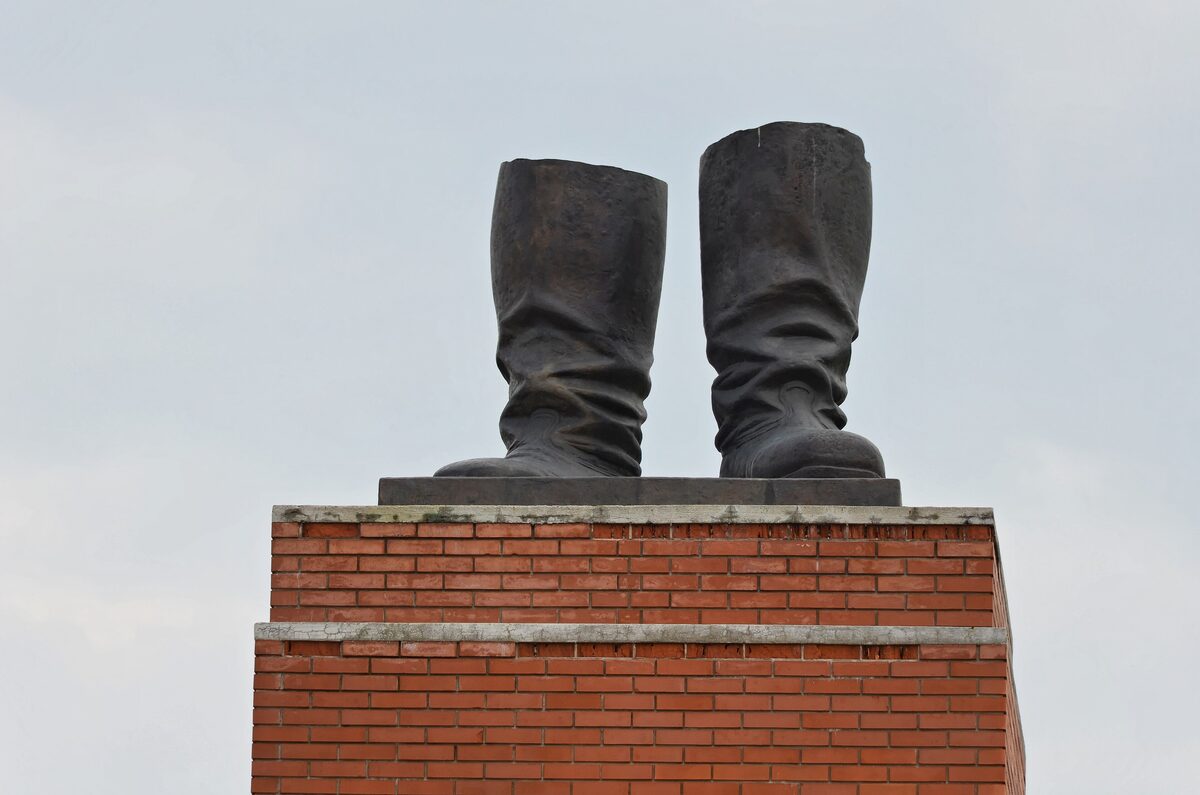 The giant bronze boots of Stalin's statue standing on a red brick plinth at Memento Park