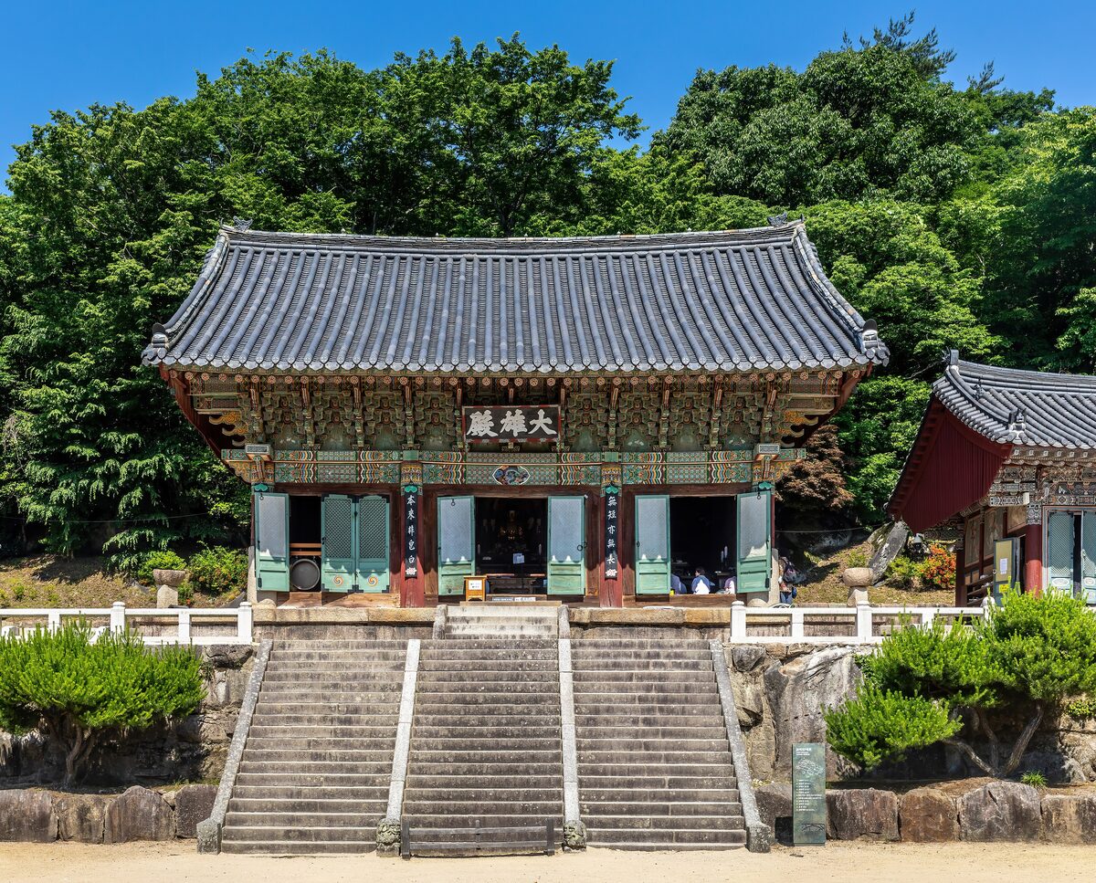 Stone stairs leading up to the front of Beomeosa temple under a blue sky