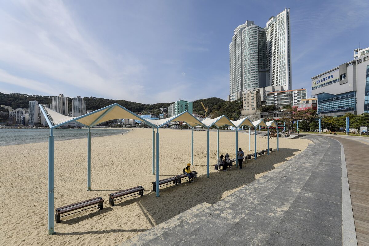 Songdo Beach with its white shade canopies over the sand and the beachfront towers behind