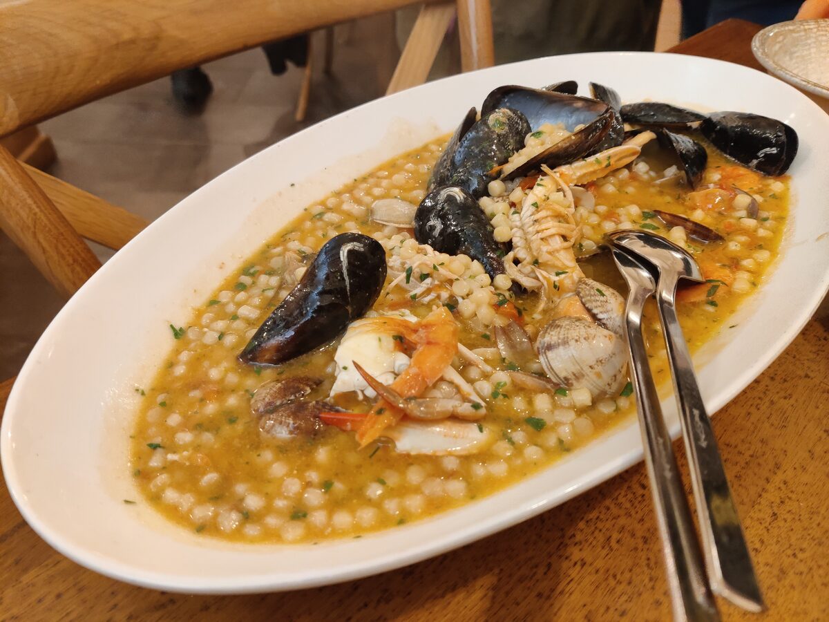 A platter of fregola, the toasted Sardinian pasta, in a saffron broth with clams and mussels