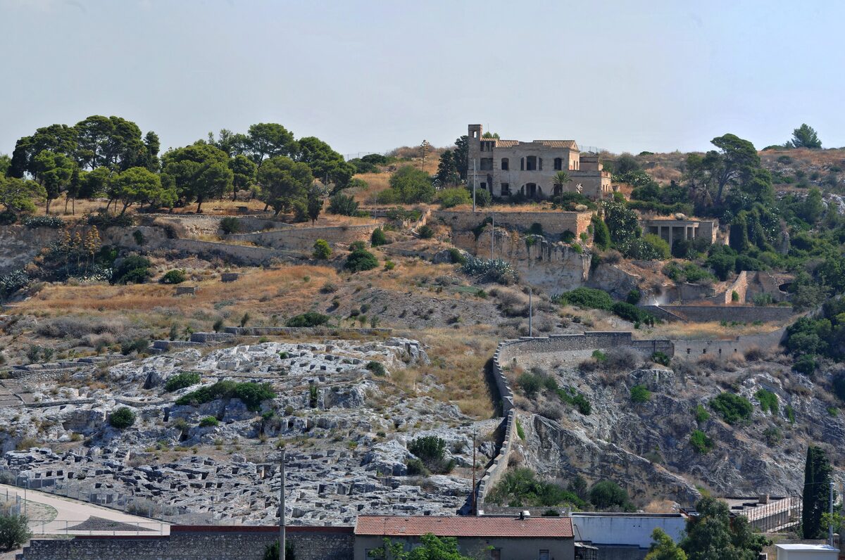 The Tuvixeddu hillside with the rock-cut tombs of the Punic necropolis in the foreground and a villa on the ridge above