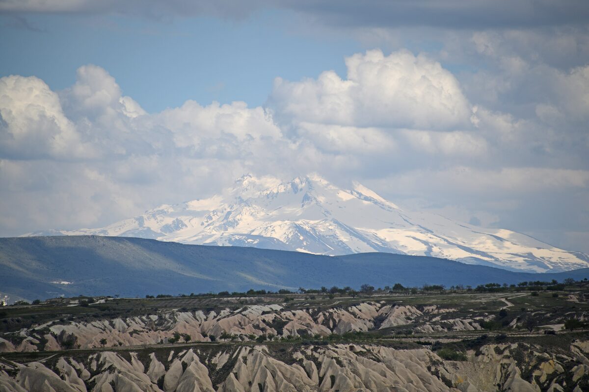 Snow-covered Mount Erciyes on the horizon beyond Göreme's eroded valleys