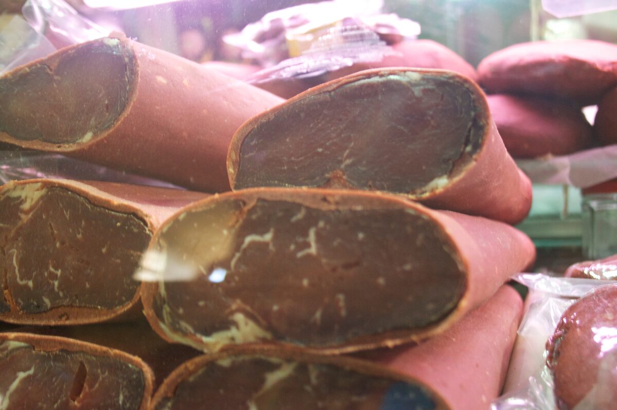Slabs of pastırma, cured beef with a red spice crust, stacked in a shop