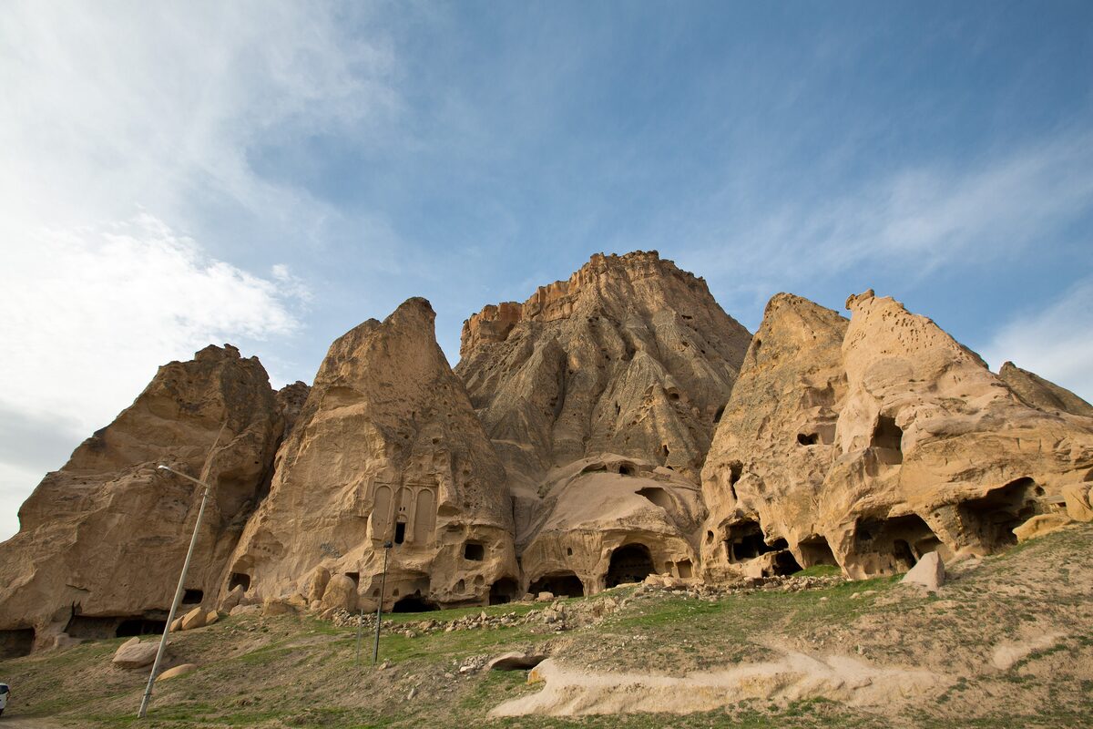 The rock-cut Selime Monastery, tall tuff cones full of doorways and windows above a grassy slope