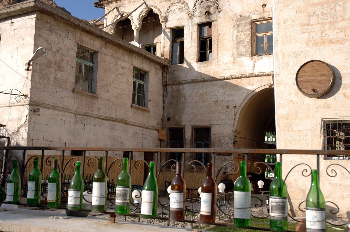 Bottles of local wine lined up in front of an old stone winery in Ürgüp