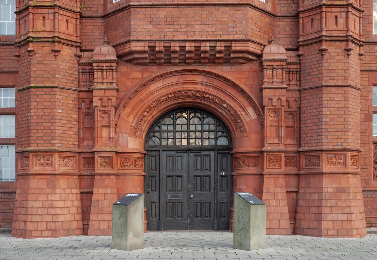 The red terracotta front of the Pierhead Building in Cardiff Bay, with its arched doorway and decorated brickwork
