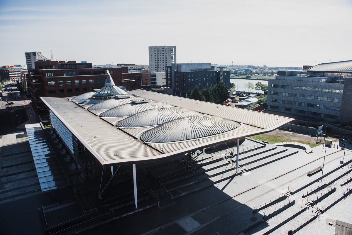 The Senedd, the Welsh Parliament building, with its glass walls and wavy wooden roof canopy on a slate platform