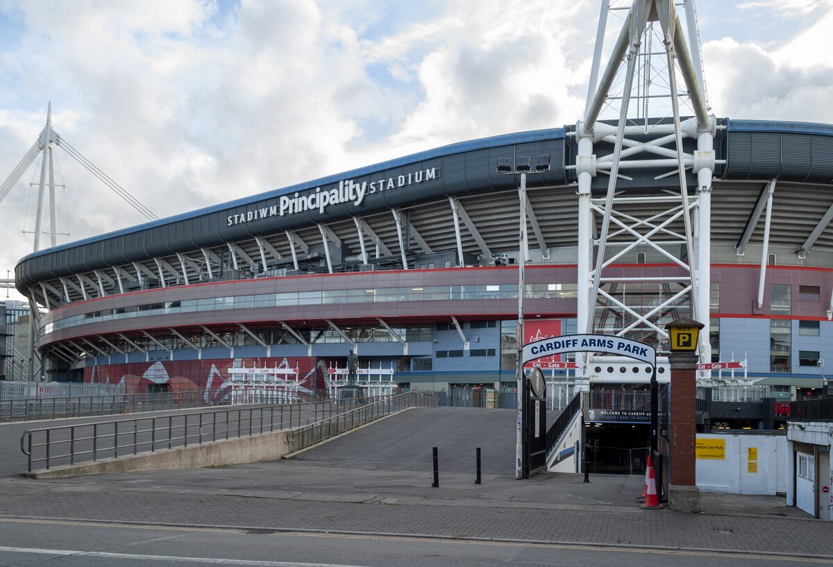 The masts and white roof of the Principality Stadium rising above the buildings of Westgate Street in Cardiff